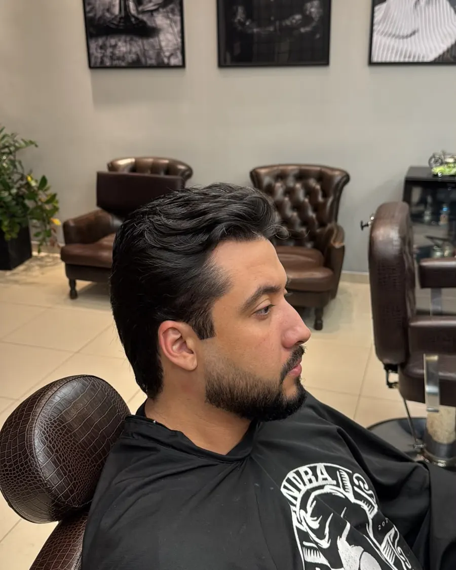Cliente de perfil com barba feita, no salão